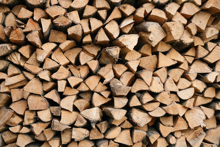 Neatly stacked firewood creates a textured background of natural wood.の写真素材