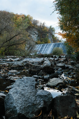 A Serene and Majestic Waterfall Wonderfully Nestled Amidst a Beautifully Vibrant Autumn Landscapeの写真素材