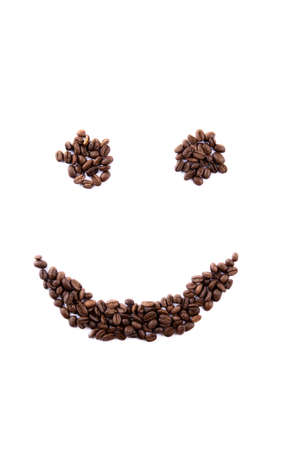 Smiley face made of coffee beans on white backgroud with copyspaceの写真素材