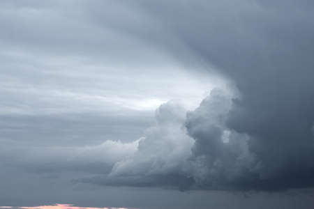 Storm clouds at sunset in a larger view. Rain is on the horizon.の写真素材