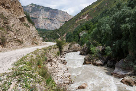 The river laid its course among the Caucasus Mountains and broke through deep canyons. A mountain river carries its waters, creating a danger for careless actions.の写真素材