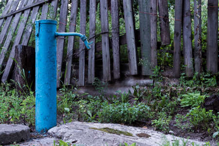 The blue broken water hydrant. Paint is very old and cracked.の写真素材