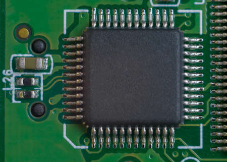 One big microscheme on green motherboard with a lot of legs. Close-up view.