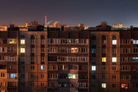 Night long exposure photo 9 and 10 floors high-rise buildings in orange colours. Big city life is...