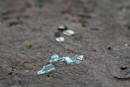 Broken glass bottles on white sand. Trash on the sand. Ecological problem.