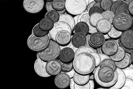 Ukrainian coins with one euro coin isolated on black background. Black and white image. Close-up view. Coins are located at the right side of frame. A conceptual image.の写真素材
