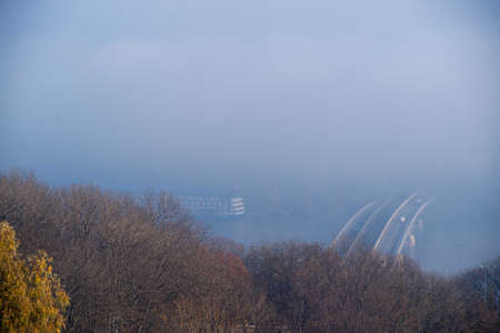 Autumn fog and river steel bridge with subway train on blurred background. Big floating boat hotel...