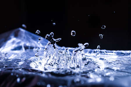 Water drops splashing on acoustic membrane. A lot of drops in air. High frequency of sound waves. Water cloud small drops. Frozen time shot.の写真素材