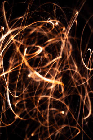 Long exposure underexposed photo of lightpainting bengali fire. Lighdrawing photo. Soft focus and a...