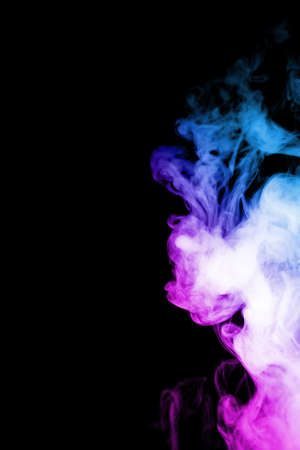 Vape clouds splash with two colours fog is blue and purple colour. Low light photo. Stock isolated on black background color smoke with spray boiling glycerine lines.の写真素材