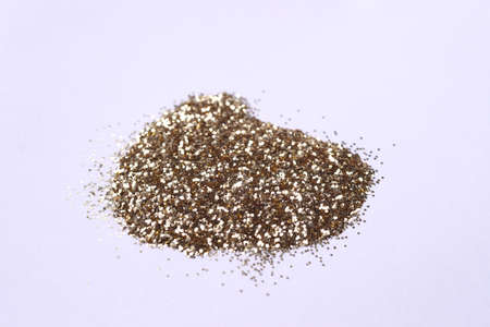 A small bunch of golden nail gritter for manicure. Yellow tone glitter shining on daylight. Stock...