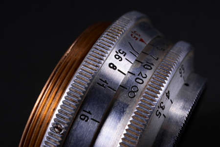 Old vintage lens scales symbols closeup view. Photo with blurred gray background. Aperture symbols and focus distance sign on lens.の写真素材