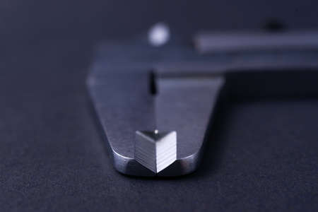 Vintage steel caliper tool closeup. Caliper tips in focus. Tool in very good condition. Scale in...