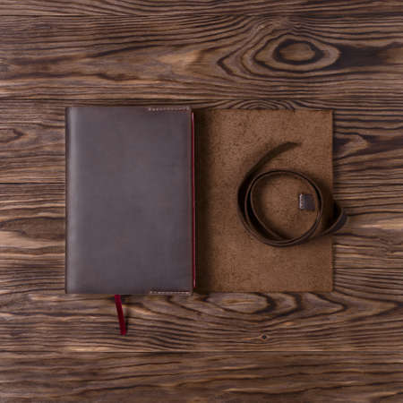Brown handmade leather notebook cover with notebook on wooden background. Stock photo of luxury business accessories. Up to down view.の写真素材