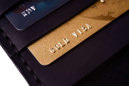 24.01.2019 Ukraine, Kyiv. A part of handmade black leather wallet isolated on white background closeup. A lot of plastic cards in purse pockets. Editorial use only.のeditorial素材