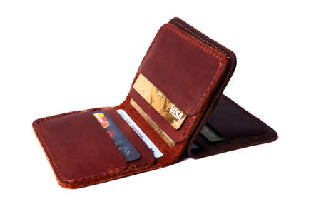 24.01.2019 Ukraine, Kyiv. Handmade red and brown color leather cardholders isolated on white background closeup. A lot of plastic cards in pockets. Editorial use only.のeditorial素材