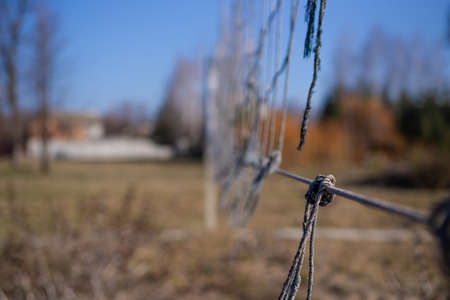 Torn volleyball net in an abandoned stadium. It`s autumn time outside. Post apocalyptic concept.の写真素材