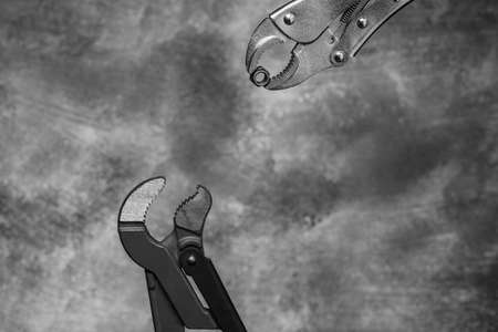 Creative image of plumbing wrenches as birds on gray background. Black and white unusual bird story. の写真素材