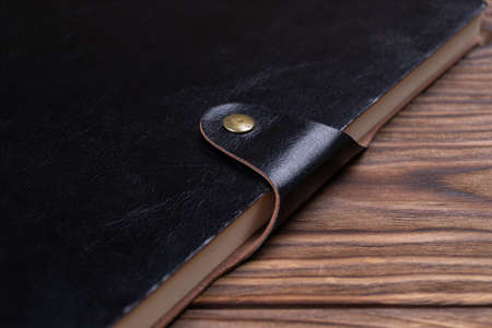A part of black gloss formal daily planner on old wooden background. Branding mockup. の写真素材