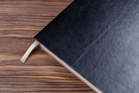 A part of black gloss formal daily planner on old wooden background. Branding mockup. の写真素材