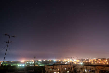 Night starry cityscape with a lot of stars and constellations. View from high rise building roof.の写真素材