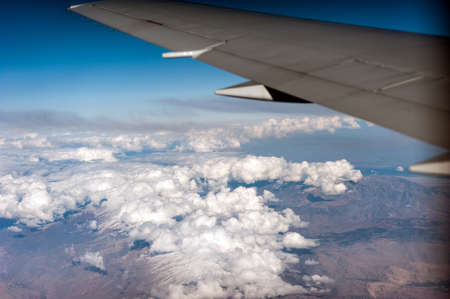 airplane wing above the clouds, blue skyの写真素材