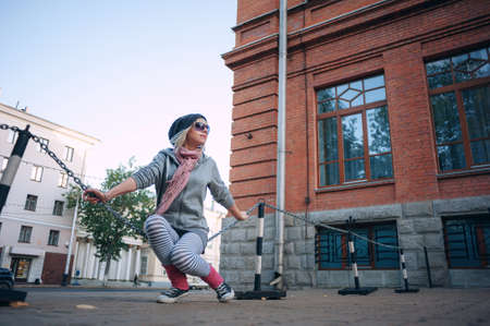 Stylish and fashionable girl on a walk around the city. Black and white knitted hat sneakers, pink socks. Outerwear, warm clothing. Fashionista. clothing items. Autumn clothes.の写真素材