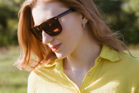 girl, beautiful, young, blonde, big sunglasses in close-up, outdoor summer, looking through his glasses, the distanceの写真素材