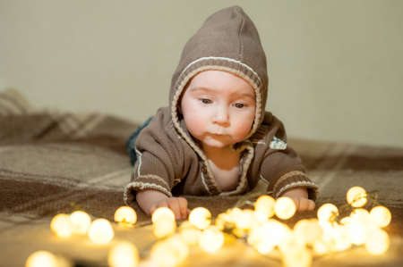 Cute baby playing on the bed, smiling and posing to the cameraの写真素材