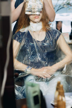 Professional Master Hairdresser coloring of dark hair women at workの写真素材