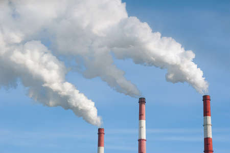 Air pollution by smoke coming out of the three factory chimneys.の写真素材