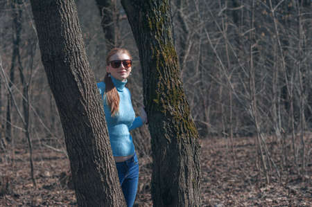 Fashionable, beautiful girl walking in the park. Tinted and filtered photo The concept of a modern youth lifestyle.の写真素材