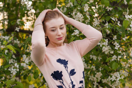 Beautiful Woman Fashion Model with Spring Blossoms Background Spring Beauty Woman with Apple Tree Flowers. Skin and hair careの写真素材