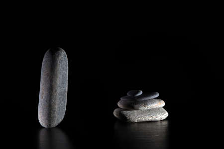 Stack of grey massage stones on dark grey backgroundの写真素材