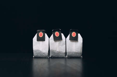 Tea bags on a dark background stand in a rowの写真素材