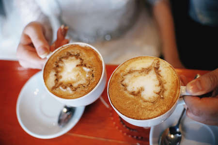 Hot coffee in the hands of a loving couple.の写真素材