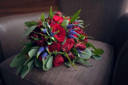 Brides bouquet of red roses before the wedding lies on a brown backgroundの写真素材