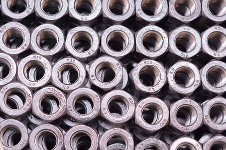 nuts in internal thread, are folded in a row. background.の写真素材