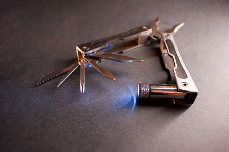 Combined pliers, multifunctional, with flashlight. Against the background of a gray texture.の写真素材