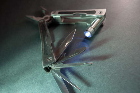 Combined pliers, multifunctional, with flashlight. Against the background of a gray texture.の写真素材