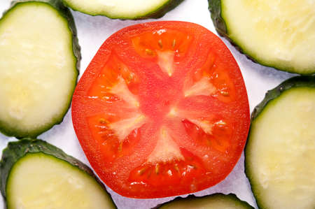 image of tomato slices and cucumber in a section. Natural background with slices of tomato. close-up, macro.の写真素材