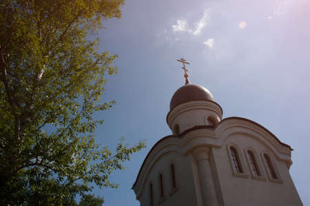 Orthodox church dome, with a cross, in the sun.