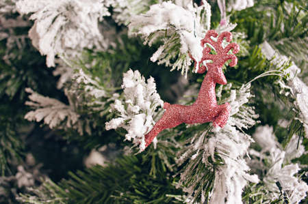 Christmas figure of red deer hanging on Christmas tree with snow. Christmas concept, new year.の写真素材