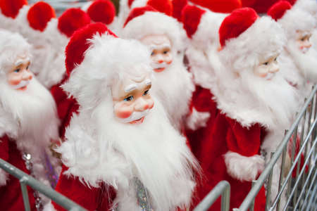 A lot of Santa Claus figurines on sale, on the counter in the storeの写真素材