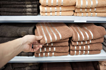 the buyer takes bath towels in bed colors from the counter from the store counterの写真素材