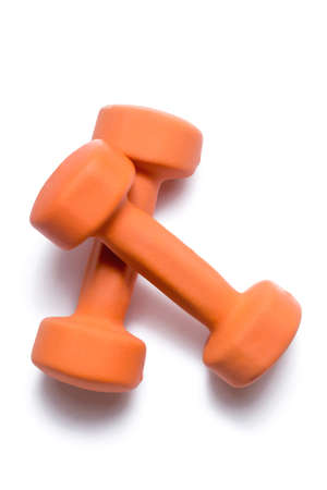 Two orange dumbbells lie on top of each other on a white background.の写真素材