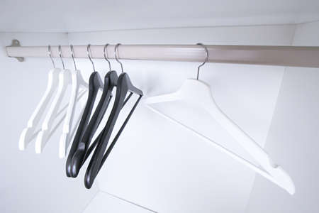 White and black empty clothes hangers, in the wardrobe.の写真素材