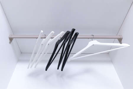 White and black empty clothes hangers, in the wardrobe.の写真素材