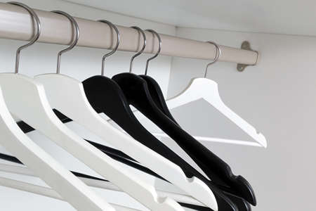 White and black empty clothes hangers, in the wardrobe.の写真素材