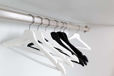 White and black empty clothes hangers, in the wardrobe.の写真素材